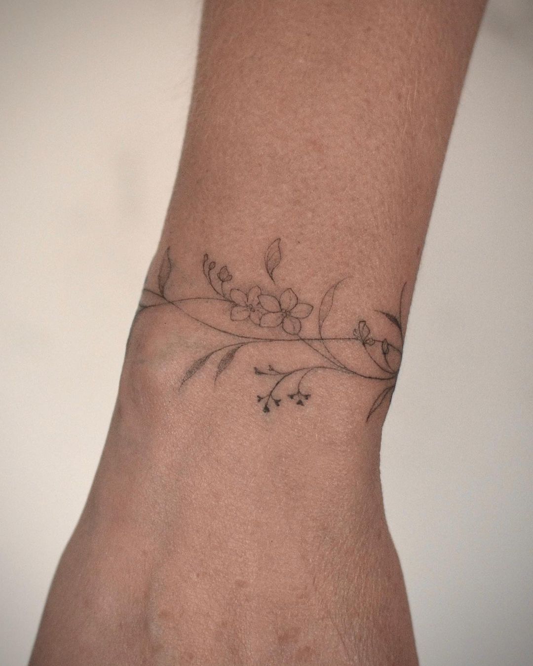 Flower bracelet tattoo on the right upper arm